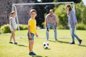 Happy family playing football in the park