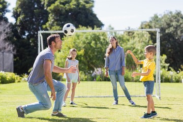 Obraz premium Happy family playing football in the park