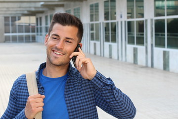 Cute student calling by phone on campus with copy space