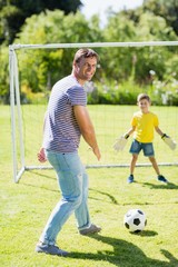 Obraz premium Father and son playing football in the park