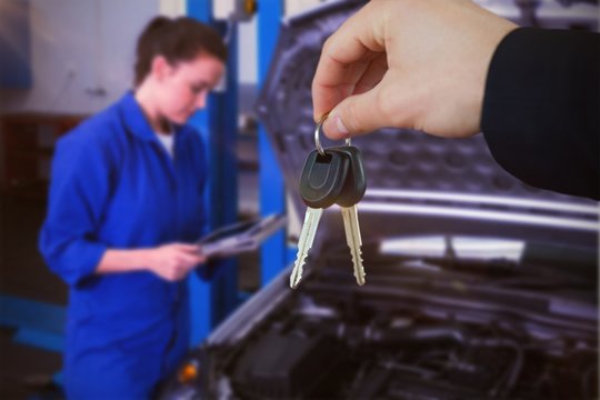 Composite image of woman smiling while receiving car keys