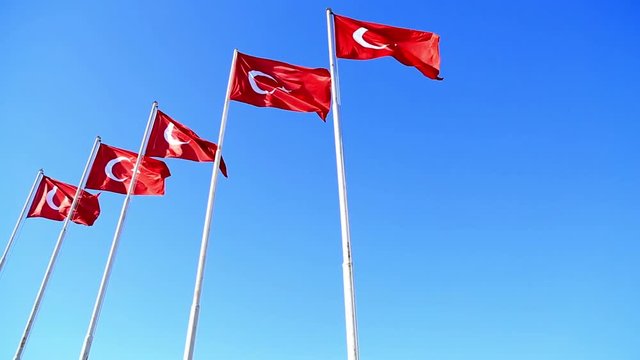 Waving flags of turkey in the blue sky