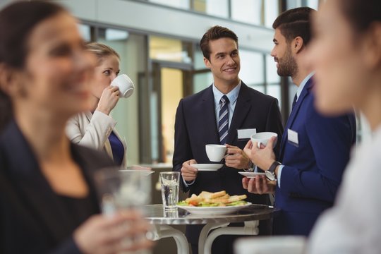 Businesspeople interacting with each other while having coffee