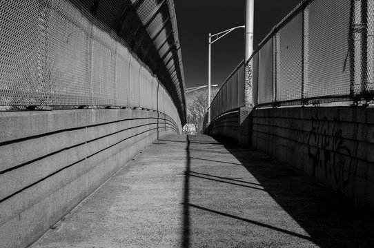 Fototapeta Urban chain link fence walkway. Industrial art and design. Overpass concrete bridge walkway.Black and white. Abstract art and design. Outdoor architectural detail and design. Abstract colors. 