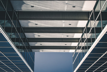 Obraz premium Urban Geometry, looking up to glass building. Modern architecture, glass and steel. . Abstract architectural design. Inspirational, artistic image.Minimal art. Architectural design. Building exterior.