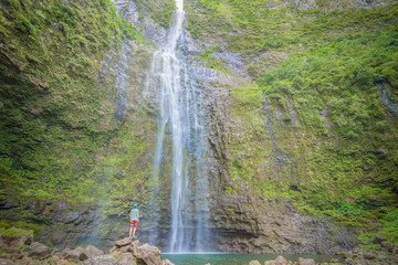 Happy man enjoying the amazing Hanakapi'ai falls in Kauai island, Hawaii