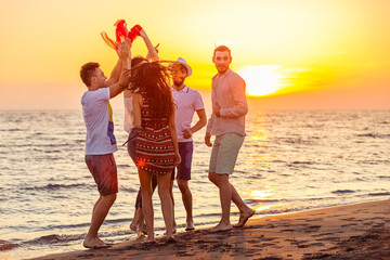 Young People Dancing On Beach at Sunset