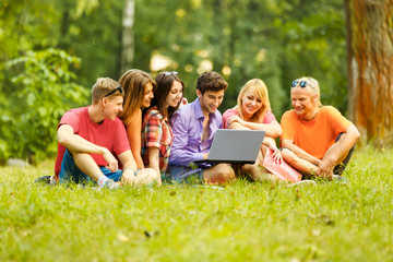 Fototapeta premium a group of students with laptop relaxing in the Park on a Sunny 