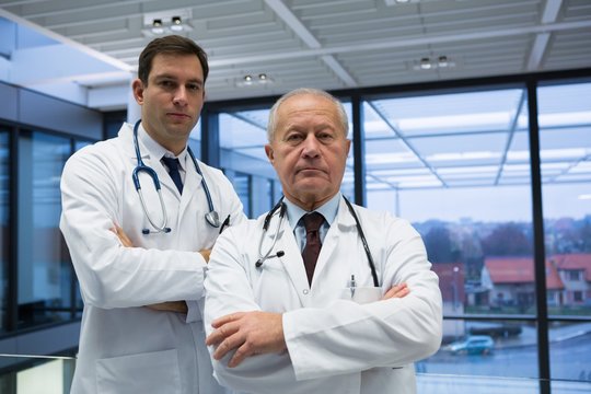 Portrait of male doctors standing with arms crossed