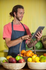Smiling male staff using digital tablet in organic section