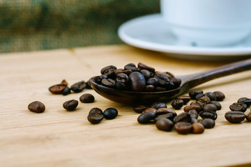 Coffee beans in wood spoon over the chop board