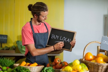 Male staff writing on slate board in organic section - Powered by Adobe