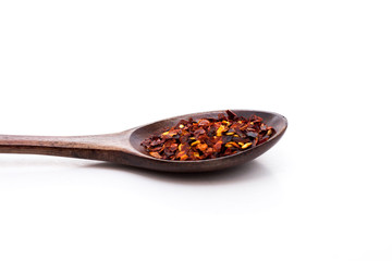 Chilli flakes in wooden spoon isolated