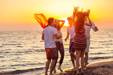 Young People Dancing On Beach at Sunset