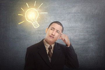 Thinking asian businessman got idea with bright light bulb over his head