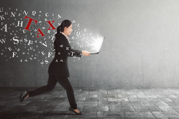 Beautiful asian business woman running with taxes from her laptop
