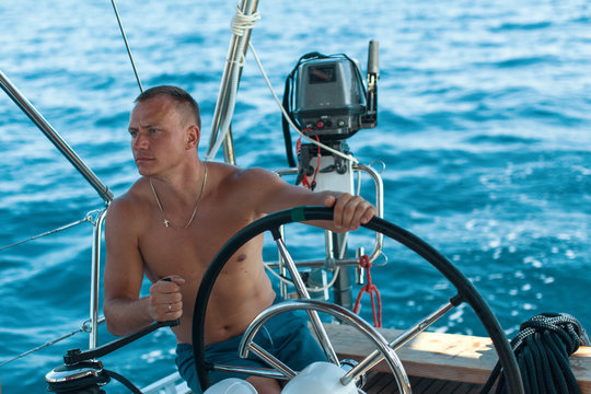 Men skipper on the yacht during the sail races in the sea. Sailing, extreme sports, luxury leisure and healthy lifestyle.
