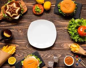 Top view of delicious hamburger, with vegetables,  on a wooden background.
