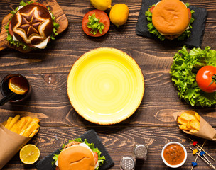 Top view of delicious hamburger, with vegetables,  on a wooden background.