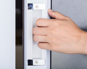 Naklejka premium Hand opening the glass door