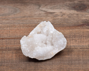 Fototapeta na wymiar Clear crystal quartz geode with crystalline druzy center on wooden vintage tray background