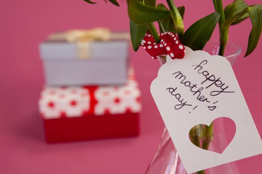 Close-up of happy mothers day card on flowers vase