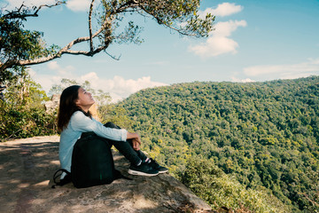 Naklejka na ściany i meble woman hiking sit down enjoy the beautiful view at mountain for sun light