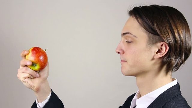 Young man sniffing an apple