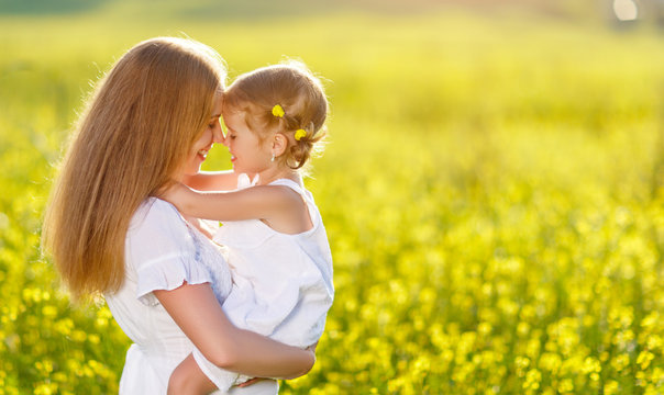 Happy family mother and child daughter embrace  on nature in summer