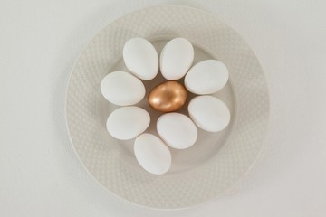 Fototapeta na wymiar White and golden easter eggs in plate