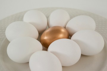 White and golden easter eggs in plate