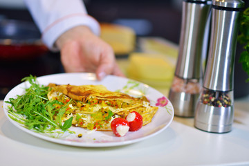 Man's hand holding an egg. White chicken egg. Chef starts preparing omelet.