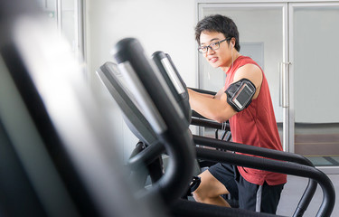 Fototapeta na wymiar handsome man on running machine in gym, fitness room