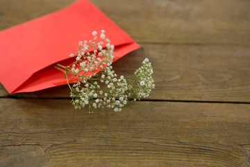 White flower in envelope on wooden plank