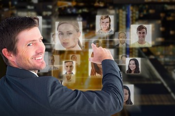 Composite image of businessman pointing with his finger