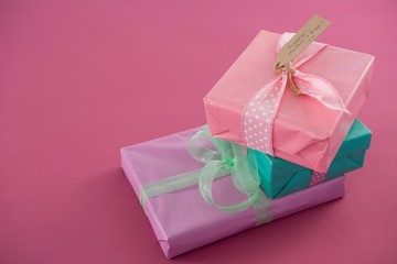 Gift boxes with happy mother day tag against pink background