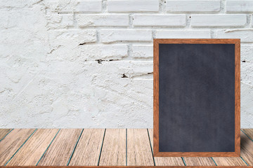 Chalkboard wood frame, blackboard sign menu on wooden table and with brick background with copy space, Template mock up for adding your design and leave space beside frame for adding more text.