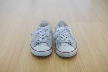 Dirty old sneakers on floor in the room
