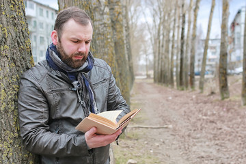 man read book tree park