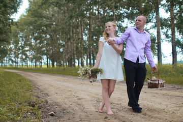 Obraz premium Just married lovers walking in a field in autumn day