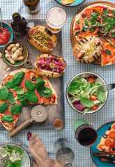 Various homemade pizza, different hot dogs, wine, beer and snack