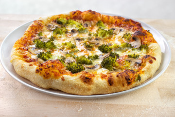 Home baked pizza with broccoli , mushrooms and mozzarella cheese on wooden baking board - 141450953