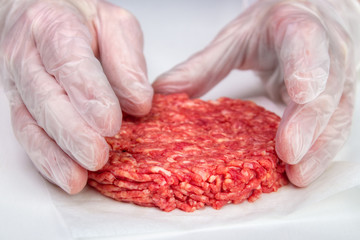 Hand shaping burger patty with vinyl gloves for hygiene - 141450968