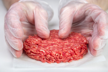 Hand shaping burger patty with disposable vinyl gloves - 141450970