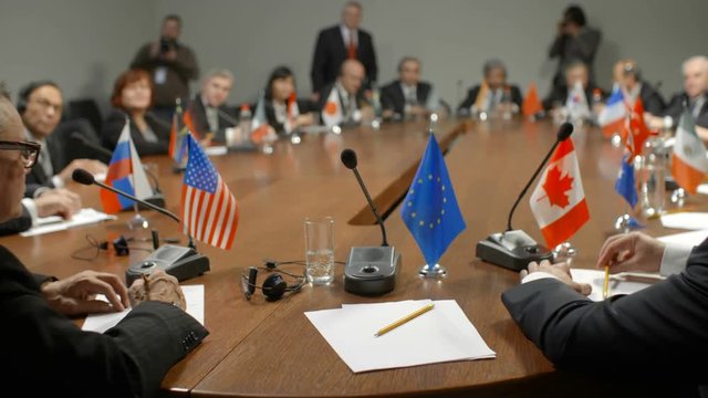 First-person view at round table. European Union delegation during high level political discussions at international summit. Participants of economic conference or forum applaud the speaker and vote