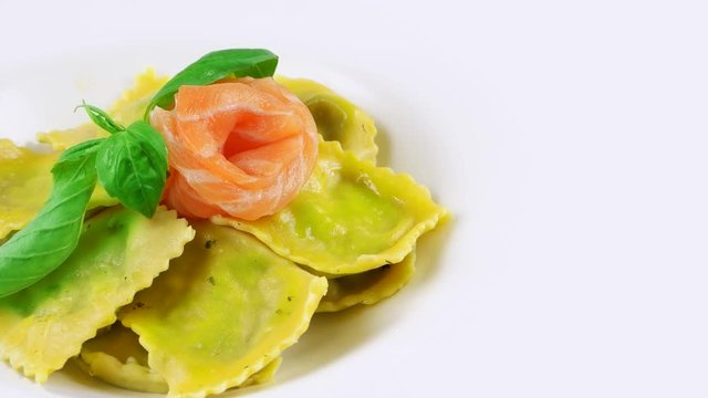 Edge of plate with Restaurant Italian ravioli pasta, copy space in right side, salmon and basil leaf
