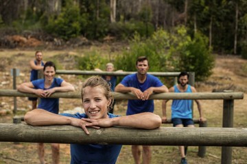 Group of people leaning on hurdles during obstacle training