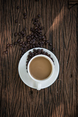 Top view of Coffee cup and coffee beans on wooden table.