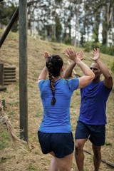 Couple giving high five to each other during obstacle course