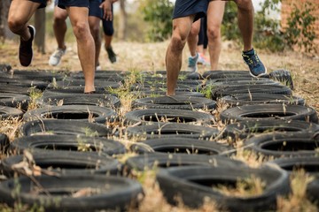 Low section of people receiving tire obstacle course training